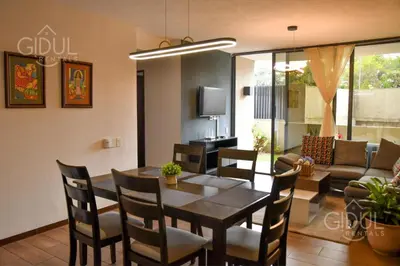 a dining room with a table and chairs and a couch at Infinity Pool Apartment in San Salvador