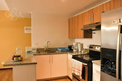 a kitchen with white cabinets and a stove top oven at Infinity Pool Apartment in San Salvador