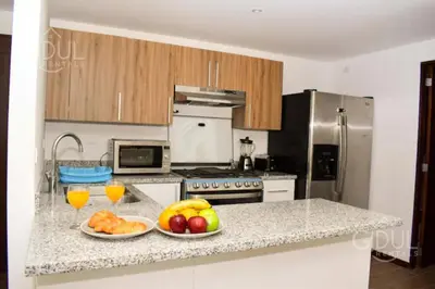 a kitchen with two plates of fruit on a counter at Infinity Pool Apartment in San Salvador