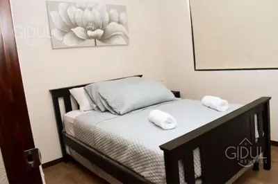 a bedroom with a bed with two towels on it at Infinity Pool Apartment in San Salvador
