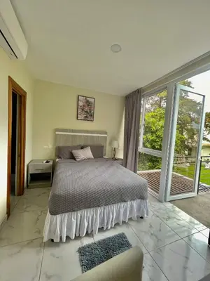 a bedroom with a bed and a large window at Hotel Finca San Nicolas in San Salvador