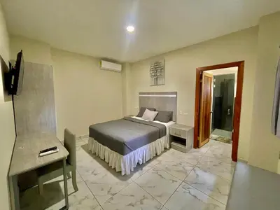 a bedroom with a bed and a television in it at Hotel Finca San Nicolas in San Salvador