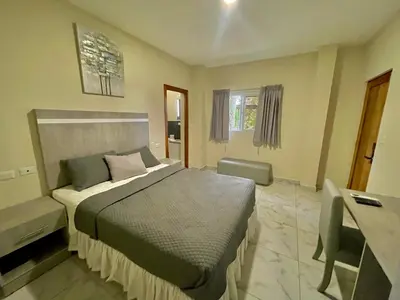 a bedroom with a bed and a desk in it at Hotel Finca San Nicolas in San Salvador