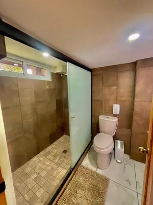 a bathroom with a toilet and a glass door at Hotel Finca San Nicolas in San Salvador
