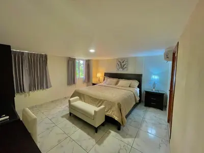 a bedroom with a large bed and a chair at Hotel Finca San Nicolas in San Salvador