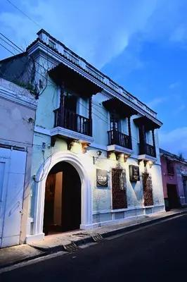 a blue building with an arch and balconies on a street at Ricks hostel Santa Ana in Santa Ana