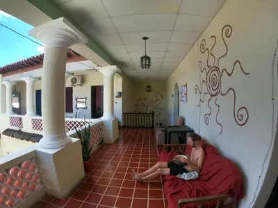 a man sitting on a chair in a hallway at Ricks hostel Santa Ana in Santa Ana
