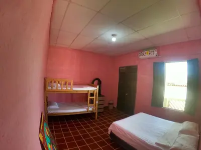 a small room with two beds and a window at Ricks hostel Santa Ana in Santa Ana