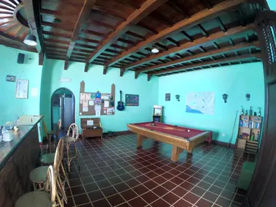a room with a pool table in the middle of it at Ricks hostel Santa Ana in Santa Ana