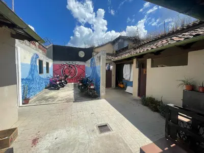 a building with two motorcycles parked in a courtyard at Ricks hostel Santa Ana in Santa Ana