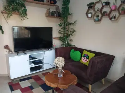 a living room with a couch and a television at La Casa Del Pinito in Sonsonate