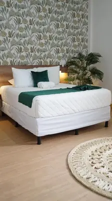 a bedroom with a white bed in a room at Kali Hotel in Santa Ana