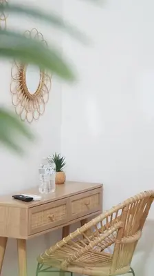 a chair next to a wooden desk with a mirror at Kali Hotel in Santa Ana