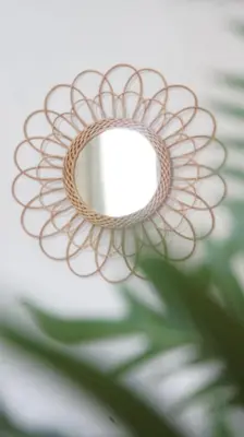 a mirror with a flower design on a wall at Kali Hotel in Santa Ana