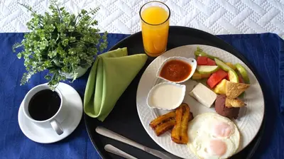a plate of breakfast food with a cup of coffee at Kali Hotel in Santa Ana