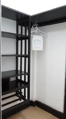 a closet with black shelves and a white wall at Kali Hotel in Santa Ana