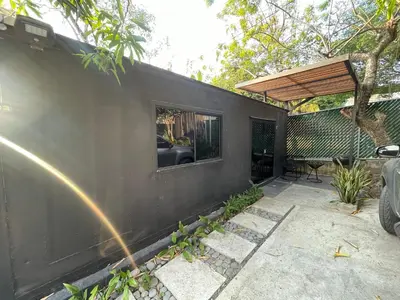 a black house with a window and a patio at The Cabins in La Libertad