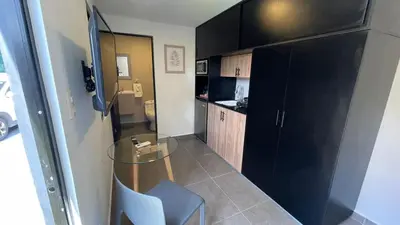 a small kitchen with a glass table and a chair at The Cabins in La Libertad