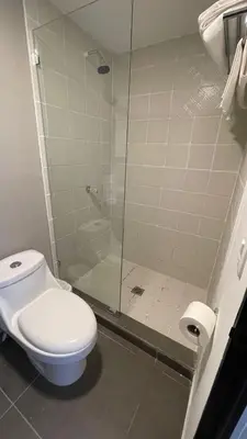 a bathroom with a toilet and a glass shower at The Cabins in La Libertad