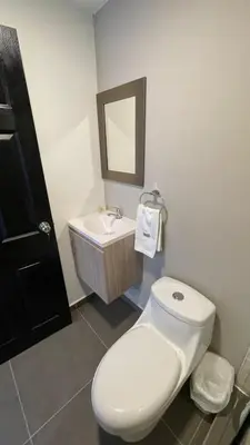 a bathroom with a white toilet and a sink at The Cabins in La Libertad