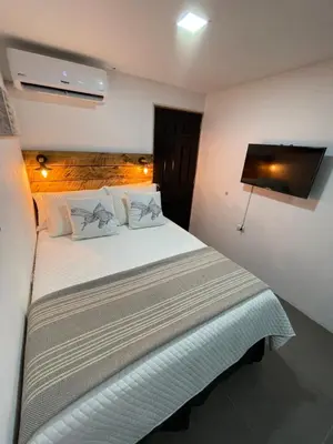 a bedroom with a large white bed in a room at The Cabins in La Libertad