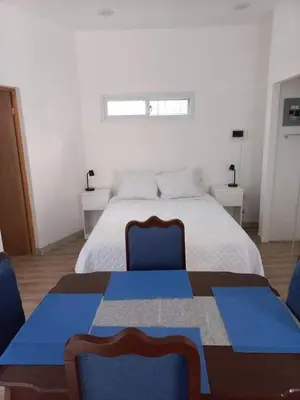 a bedroom with a bed with two blue chairs at La Leona 1 in El Zonte