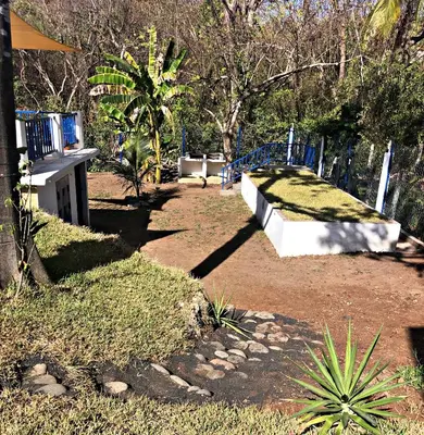 a path in a park with a blue fence at La Leona 1 in El Zonte