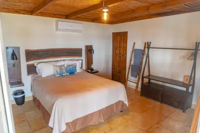a bedroom with a large bed and a piano at Casa del Golfo El Salvador in Conchagua