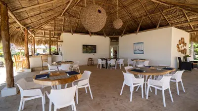 a restaurant with tables and chairs in a room at Casa del Golfo El Salvador in Conchagua