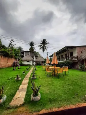 a yard with a table and chairs and grass at Hotel Tunco Lodge in La Libertad