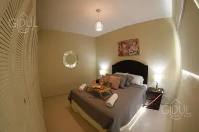 a bedroom with a bed with a table on it at The Cozy Apartment in San Salvador