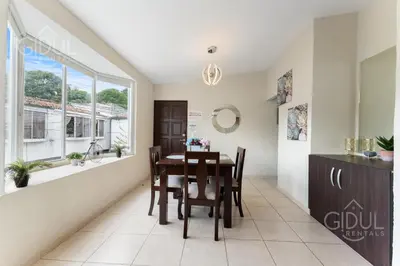 a dining room with a table and chairs and a window at The Cozy Apartment in San Salvador