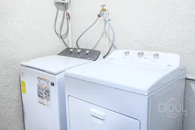 a washer and dryer sitting next to a wall at The Cozy Apartment in San Salvador