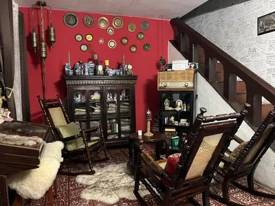 a living room with chairs and a red wall at Mendoza’s GUEST HOUSE in Santa Ana