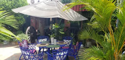 a table and chairs under an umbrella in a garden at Mendoza’s GUEST HOUSE in Santa Ana