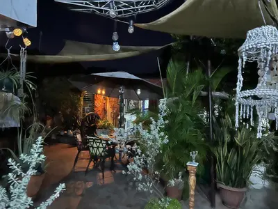 a patio with plants and tables and an umbrella at Mendoza’s GUEST HOUSE in Santa Ana