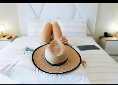 a woman with a hat laying on a bed at amaremar in San Luis