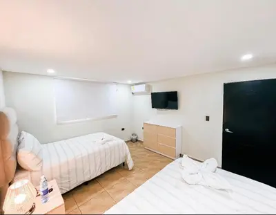 a hotel room with two beds and a tv at amaremar in San Luis