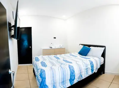 a bedroom with a bed with a blue and white comforter at amaremar in San Luis