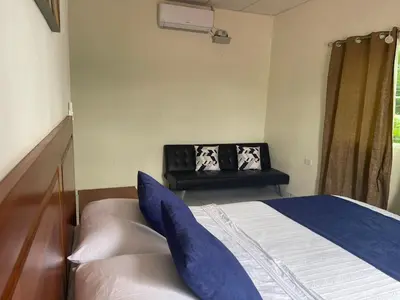 a bedroom with a bed with blue pillows on it at A 5 minutos de las Ruinas del Tazumal, Chalchuapa Santa Ana El Salvador in Chalchuapa