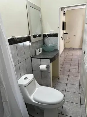 a bathroom with a white toilet and a sink at A 5 minutos de las Ruinas del Tazumal, Chalchuapa Santa Ana El Salvador in Chalchuapa