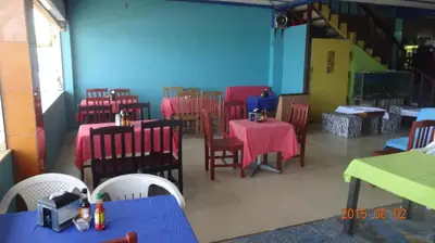 a dining room with tables and chairs and blue walls at Playa El Obispo F La Libertad Playa El Obispo in La Libertad
