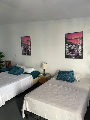 a hotel room with two beds and two pictures on the wall at Playa El Obispo B La Marea building La Libertad in La Libertad