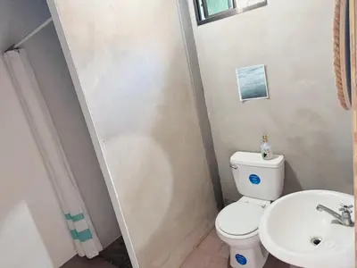 a bathroom with a toilet and a sink at La Canasta in El Zonte