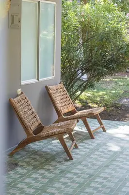 two wicker chairs sitting next to a window at La Canasta in El Zonte