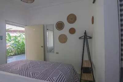 a bedroom with a bed and a clock on the wall at La Canasta in El Zonte