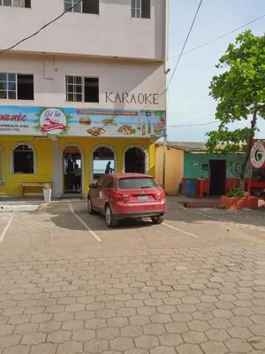 a red car parked in a parking lot in front of a building at Playa El Obipo C La Marea building La Libertad in La Libertad