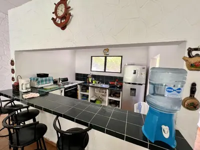 a kitchen with a counter with a water cooler on it at Beautiful beach house in Los Cobanos El Salvador in Los Cóbanos