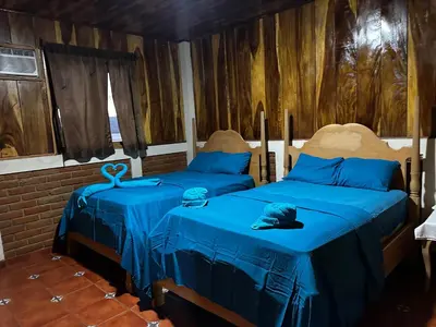 two beds in a room with blue sheets at Hotel Silver Lake in Santa Ana
