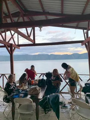 a group of people sitting around a table in front of the water at Hotel Silver Lake in Santa Ana